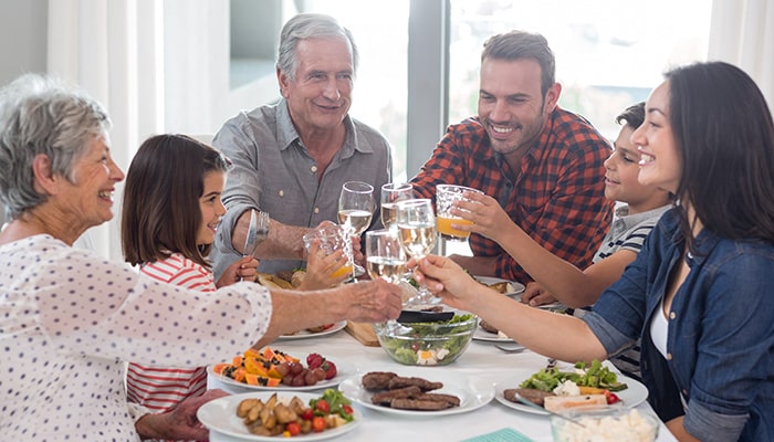 Family Sitting At Dinner Table